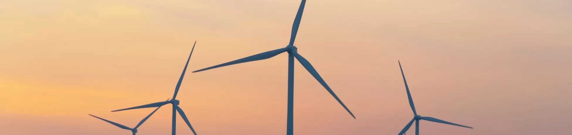 Wind turbines scattered across an orange sky